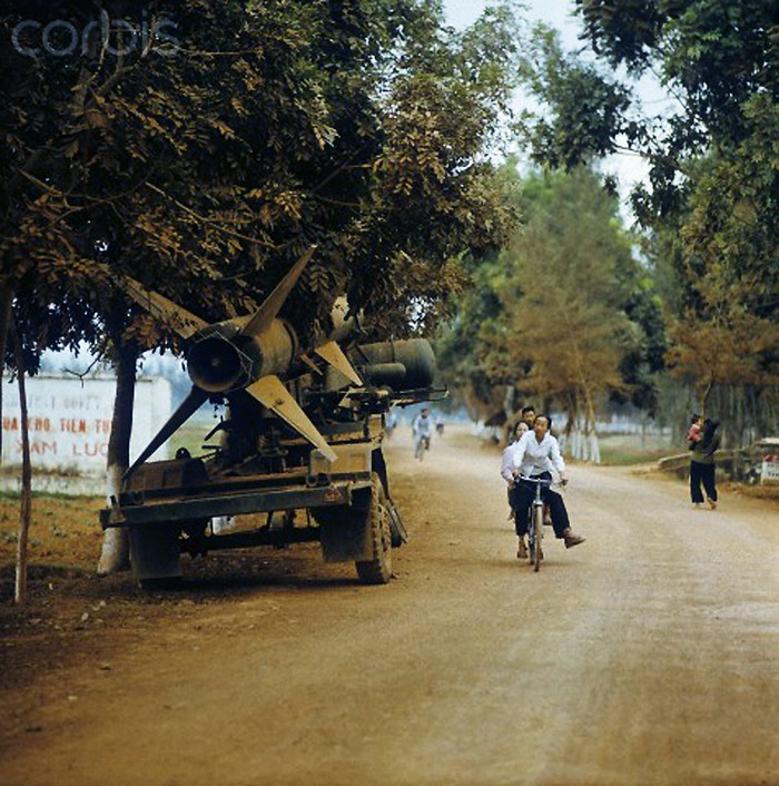 Thanh niên Việt Nam đi xe đạp trên đường quốc lộ 1, bên đường là một quả tên lửa chưa qua sử dụng. Ảnh chụp năm 1973. Nguồn: Corbis.